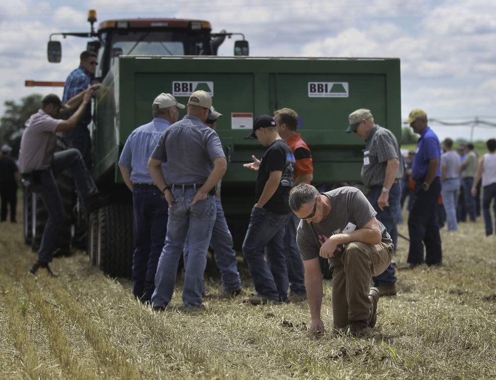 Darren Rismiller, who raises turkeys in Darke County's Allen Twp., inspects the results of a sub-surface poultry litter applicator Wednesday at Union City during a demonstration of technologies aimed to keep fewer nutrients out of runoff into waterways. CHRIS STEWART / STAFF
