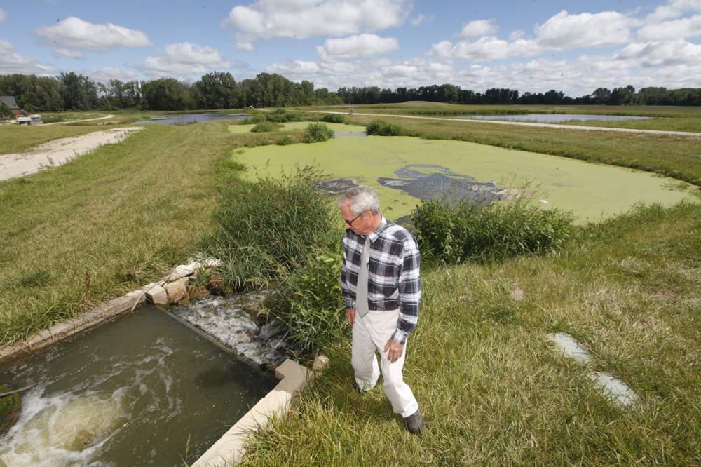 Milt Miller, Grand Lake St. Marys Restoration Commission manager, examines a "treatment train," a series of pools that mimics a natural wetland, allowing its plants to pull nutrients from the water before it enters the lake. The first functioning "treatment train" diverts water from Prairie Creek. Two more of the lake's tributaries will get treatment trains by next year. CHRIS STEWART / STAFF