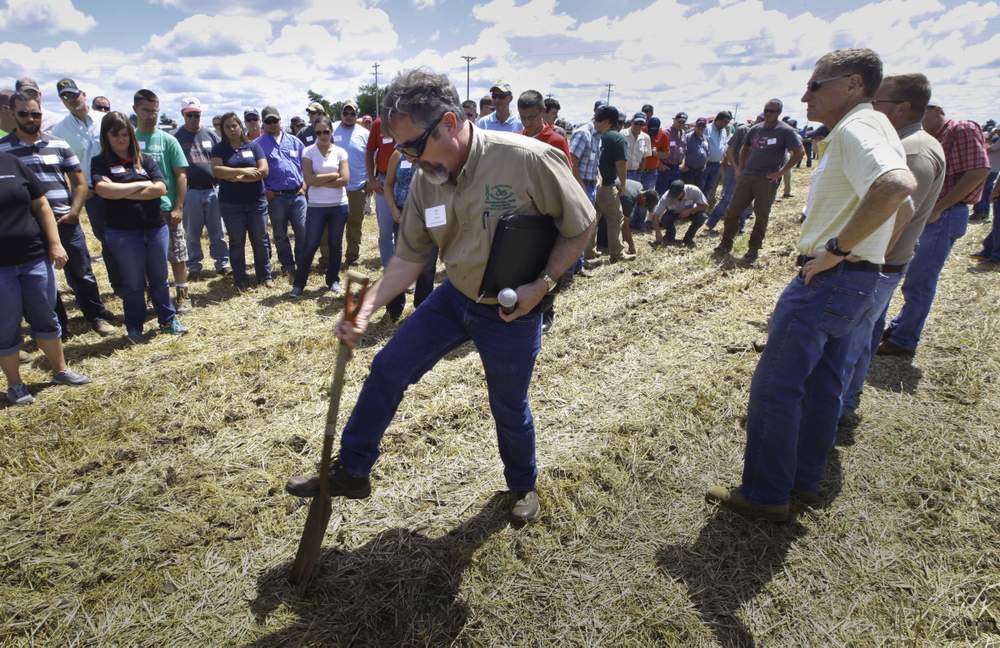 Dan Pote, a United States Department of Agriculture soil scientist, checks the depth of poultry litter applied to a field using a sub-surface applicator he helped develop at the department's Agricultural Research Service at Booneville, Ark. Pote was in Union City Wednesday for a demonstration of technologies aimed to keep fewer nutrients from running into waterways. CHRIS STEWART / STAFF